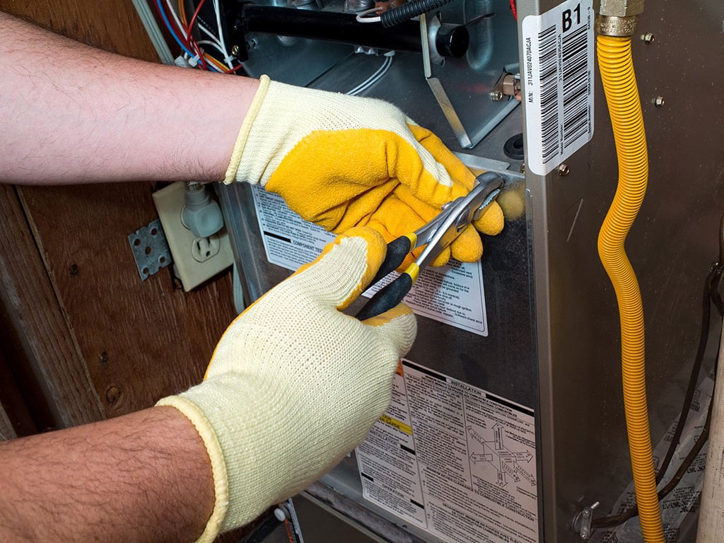 Technician preforming heating repair in St. George