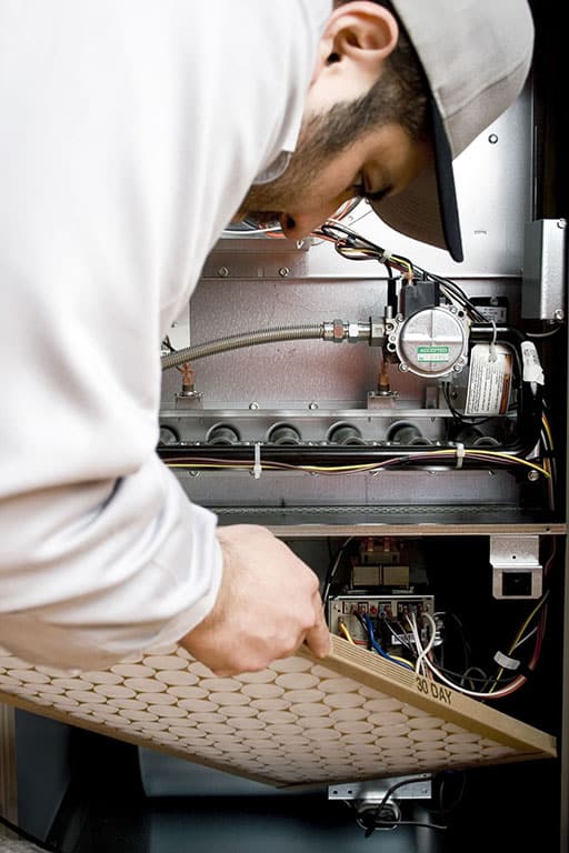 Technician preforming heating maintenance in St. George, UT