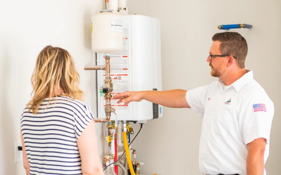Thompson Plumbing tech walking a St. George area homeowner through her water heater system during a plumbing service call