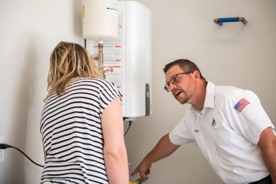 Thompson Plumbing technician consulting with a St. George Utah homeowner about tankless water heater