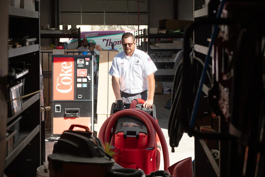 Thompson Plumbing technician moving a drain cleaning machine through the company's St. George Utah supply warehouse