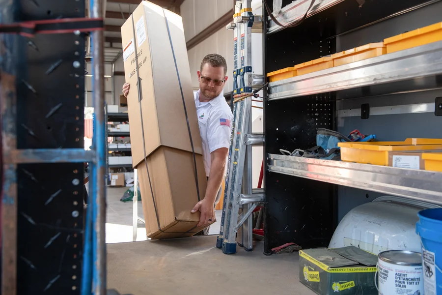 Thompson Plumbing technician loading equipment into fully stocked van to prep for a residential service call in Utah