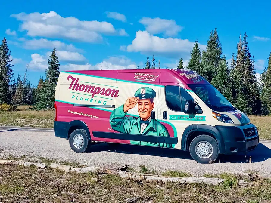 Thompson Plumbing van on a scenic Cedar City Utah mountain road surrounded by pine trees