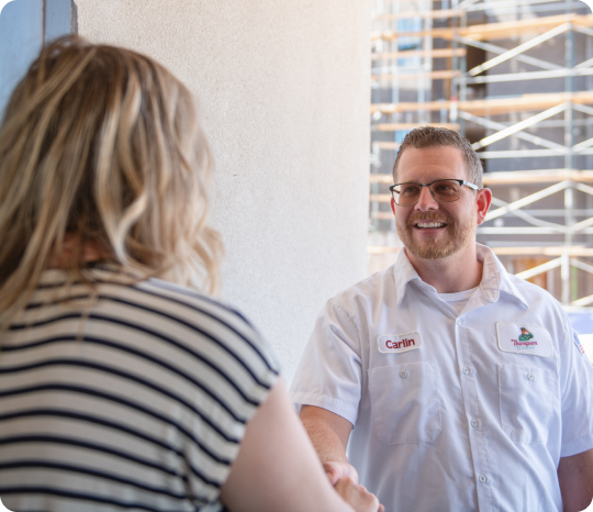  a thompson plumbing technician smiling as he shakes hands with a customer