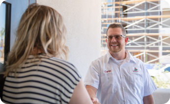  a thompson plumbing technician smiling as he shakes hands with a customer