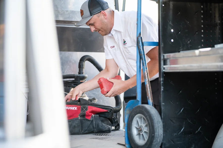 Thompson Plumbing tech Cole organizing his tool bag at the back of the service van, ready to serve Washington County customers