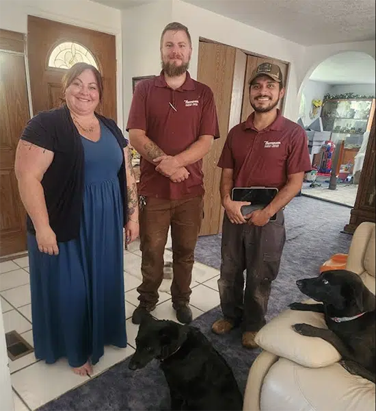 Thompson Plumbing crew with customer and dogs after water leak repair